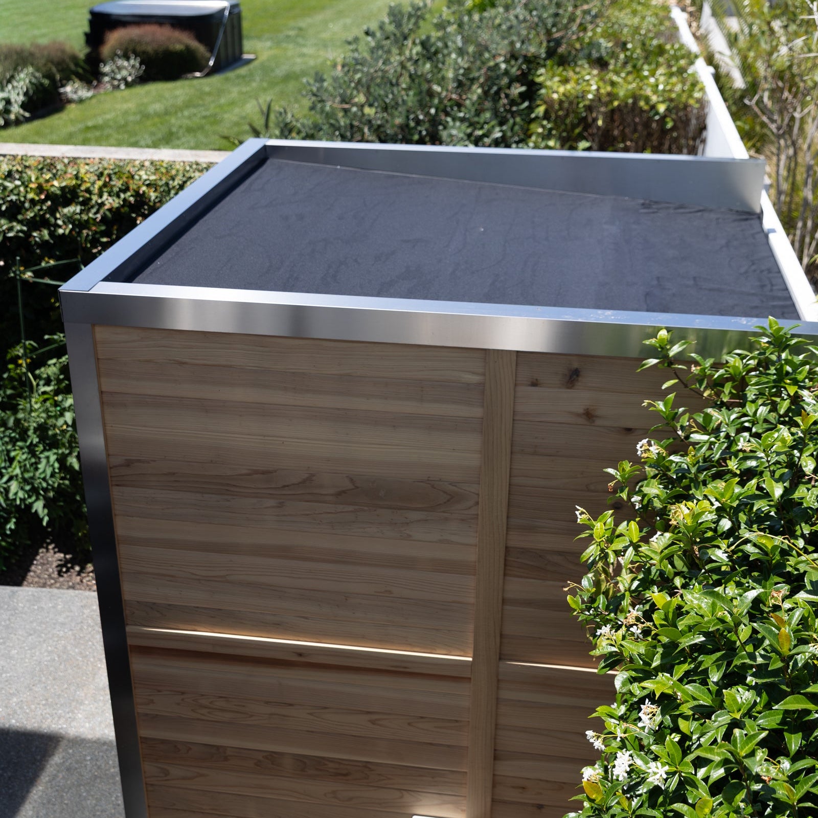 Sereno cedar outdoor sauna with stone heater in a New Zealand backyard setting